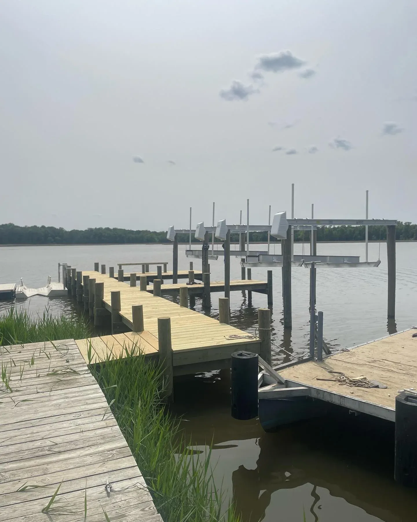 A new Dock It Marine pier with boat lifts reaching out past the marsh grass